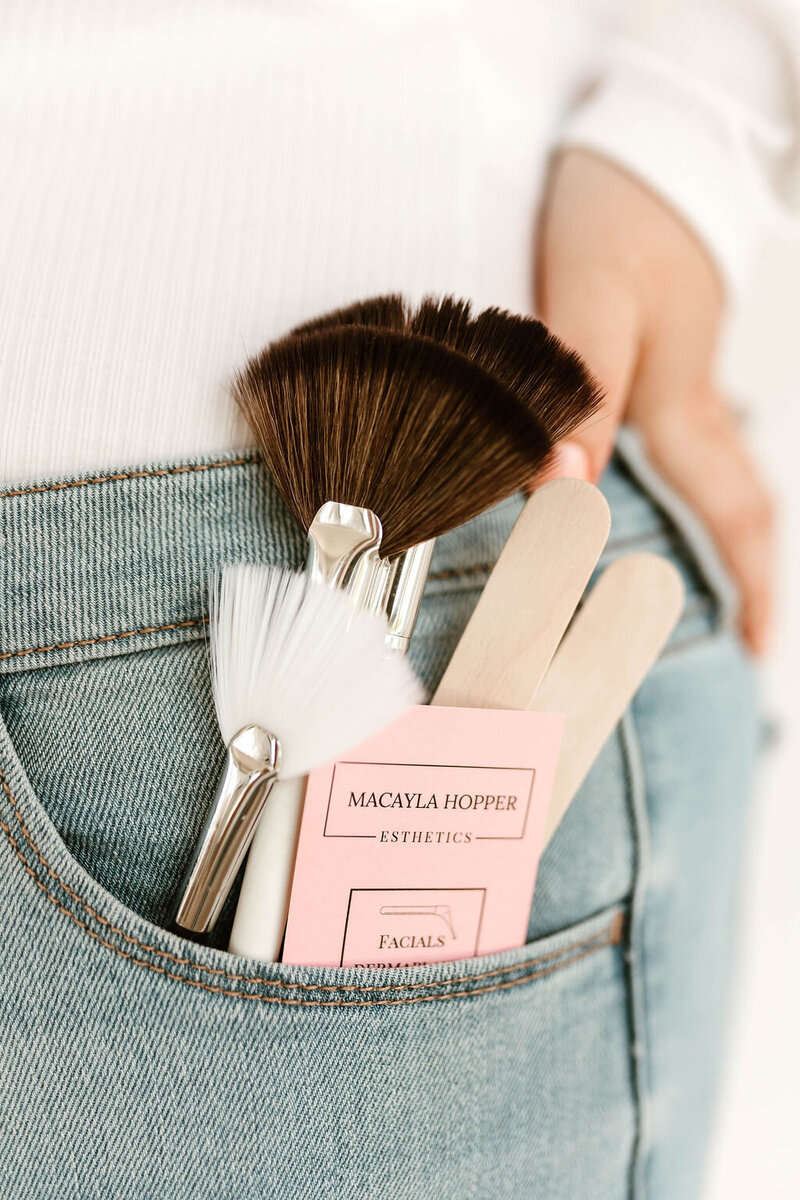 Detail photo of esthetician tools in Macayla Hopper’s back pocket, representing professional waxing and skincare