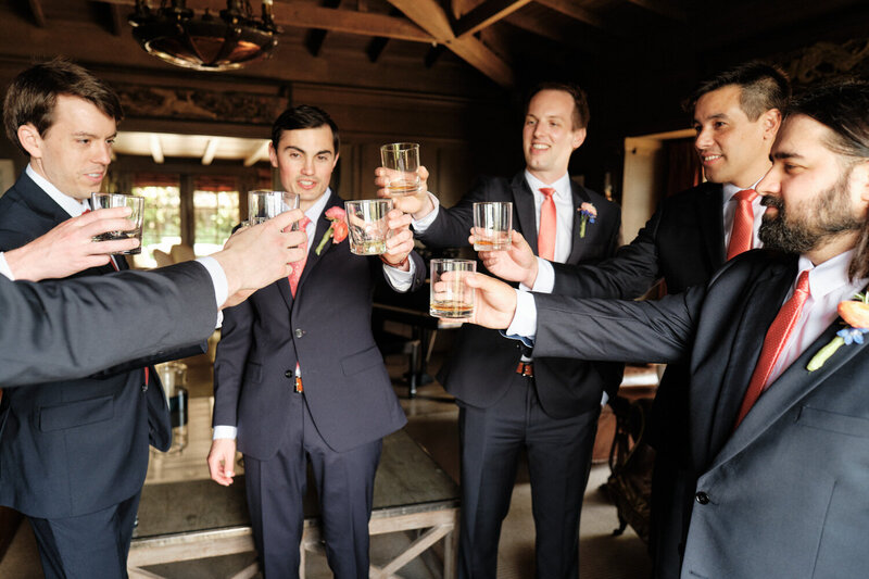Groom and groomsmen raise a glass for a pre-wedding toast