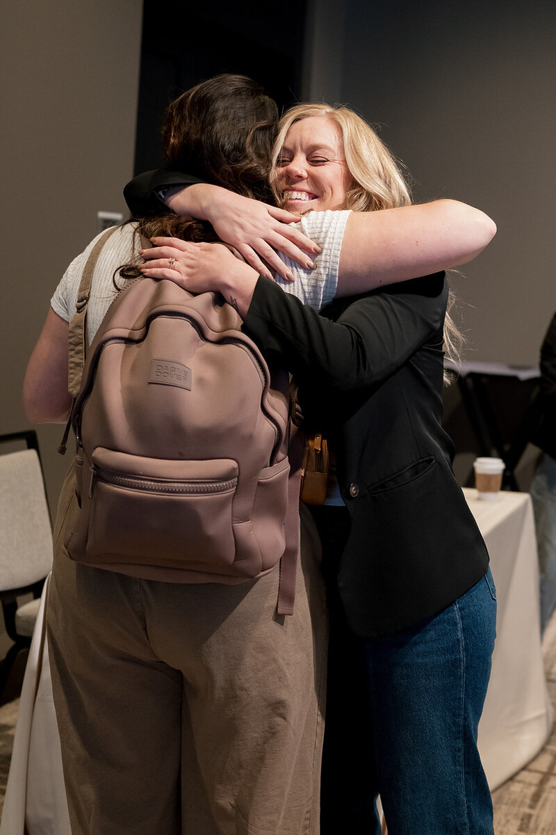 wedding professionals hugging at wedding photographer conference
