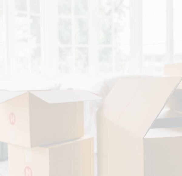 moving boxes sitting in room with large open windows in background