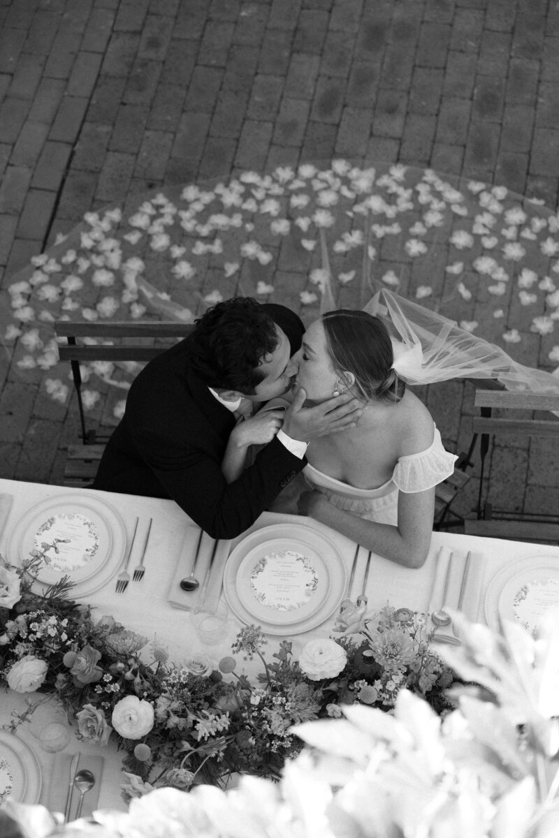 Bride and groom share an intimate kiss at their La Jolla wedding in Southern California, surrounded by romantic lighting and a joyful atmosphere.