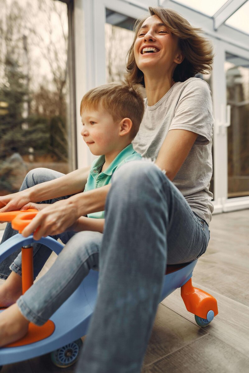 mom on scooter with toddler laughing