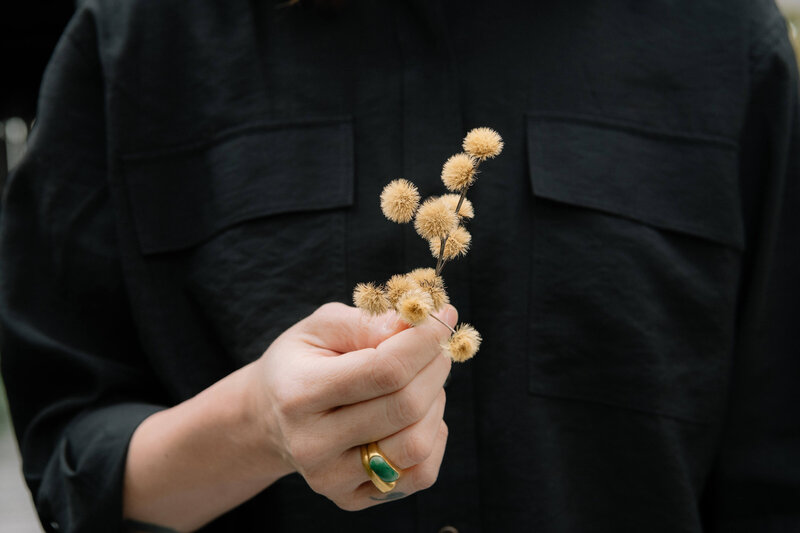 A woman’s hands gently holding golden-brown foliage, symbolizing natural beauty, abundance, and the connection to the earth in wellness.