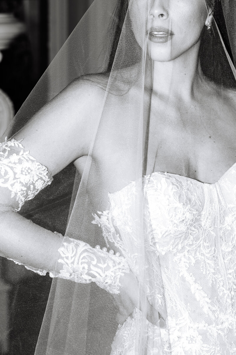 Close up black and white photo of bride's veil over her face