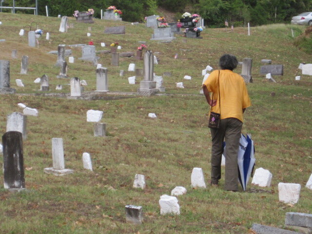 “A community member tends to headstones at Melba Lower Wharton Cemetery, a sacred space honoring Black ancestors whose lives shaped Fayetteville’s history.”
