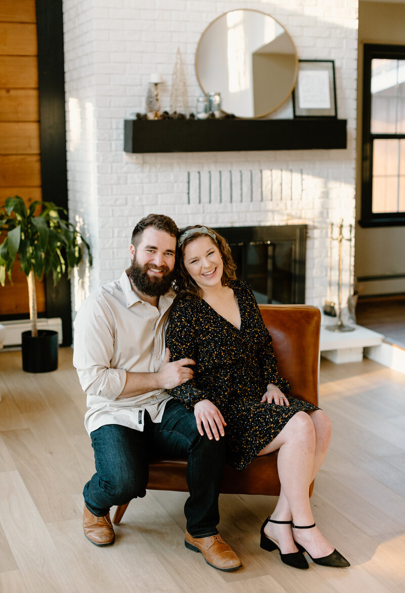 Couple in brown chair by fireplace