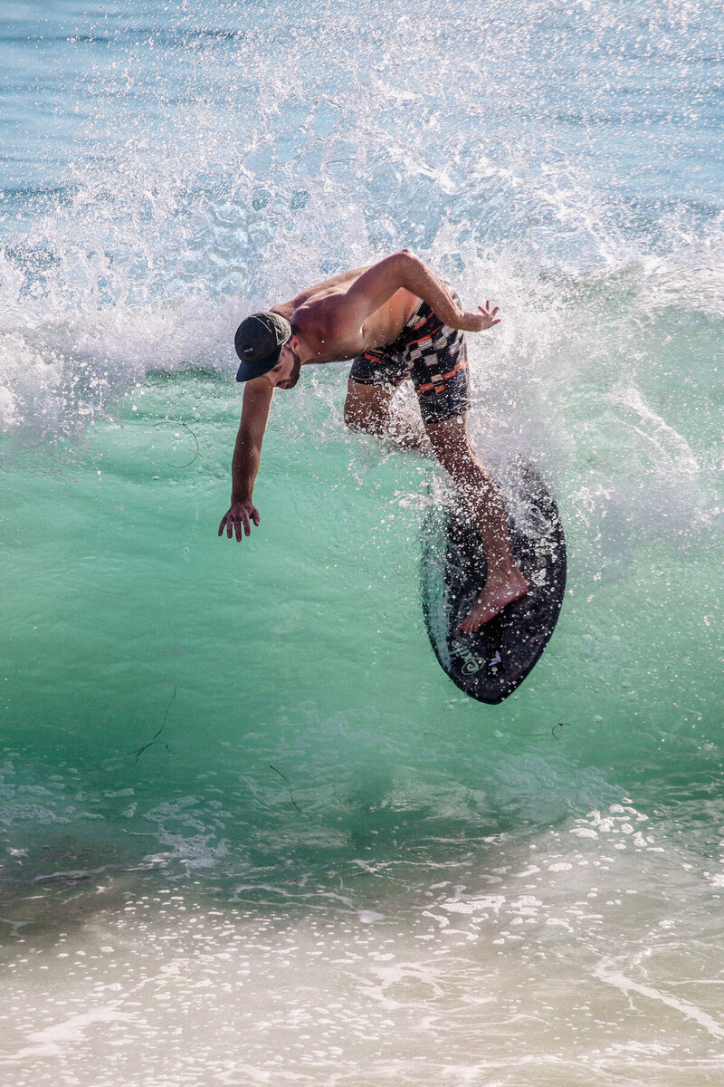 Skimboarder riding wave