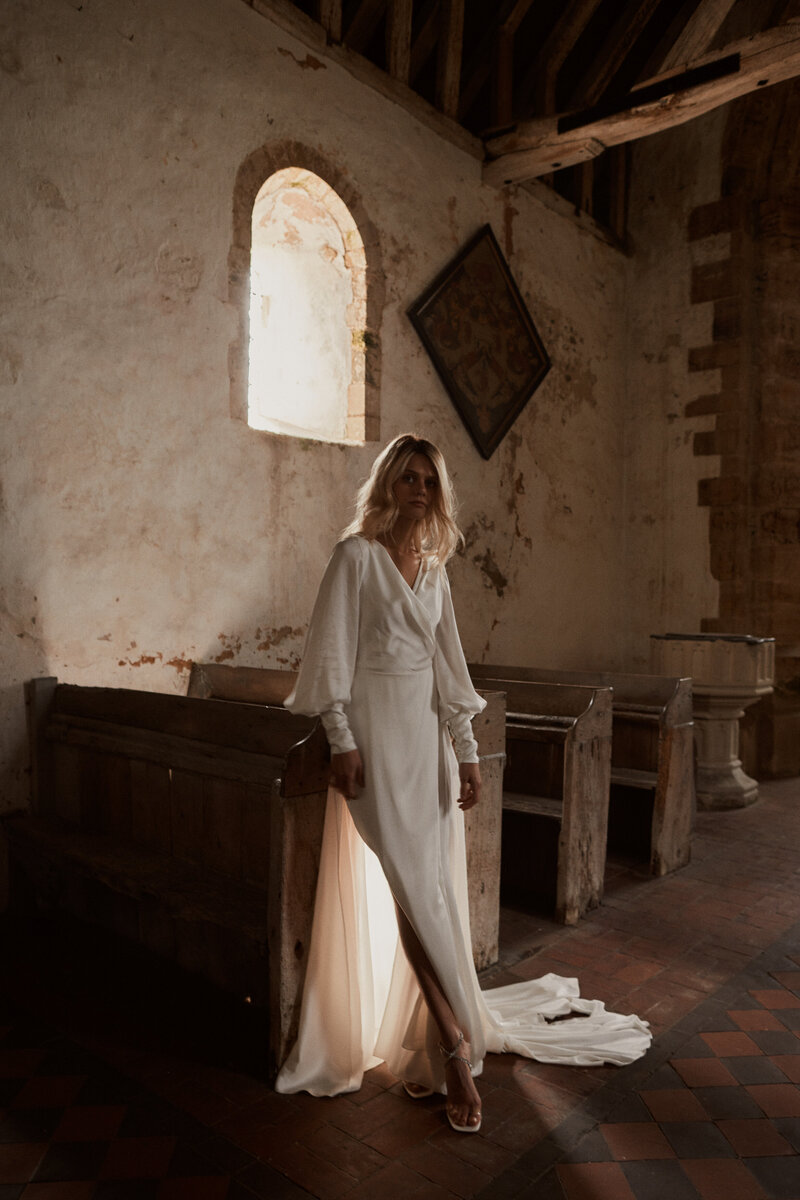 Long sleeve silk wedding dress on bride in church