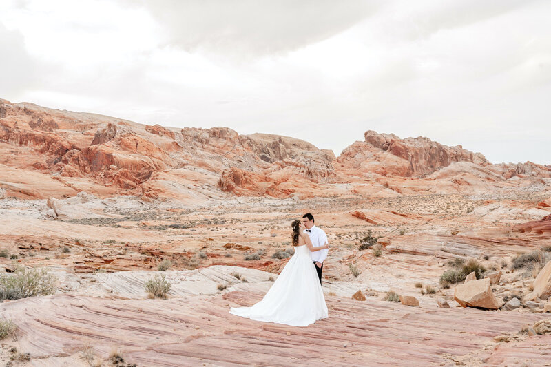 Elena and Roman kiss at their desert style adventure elopement
