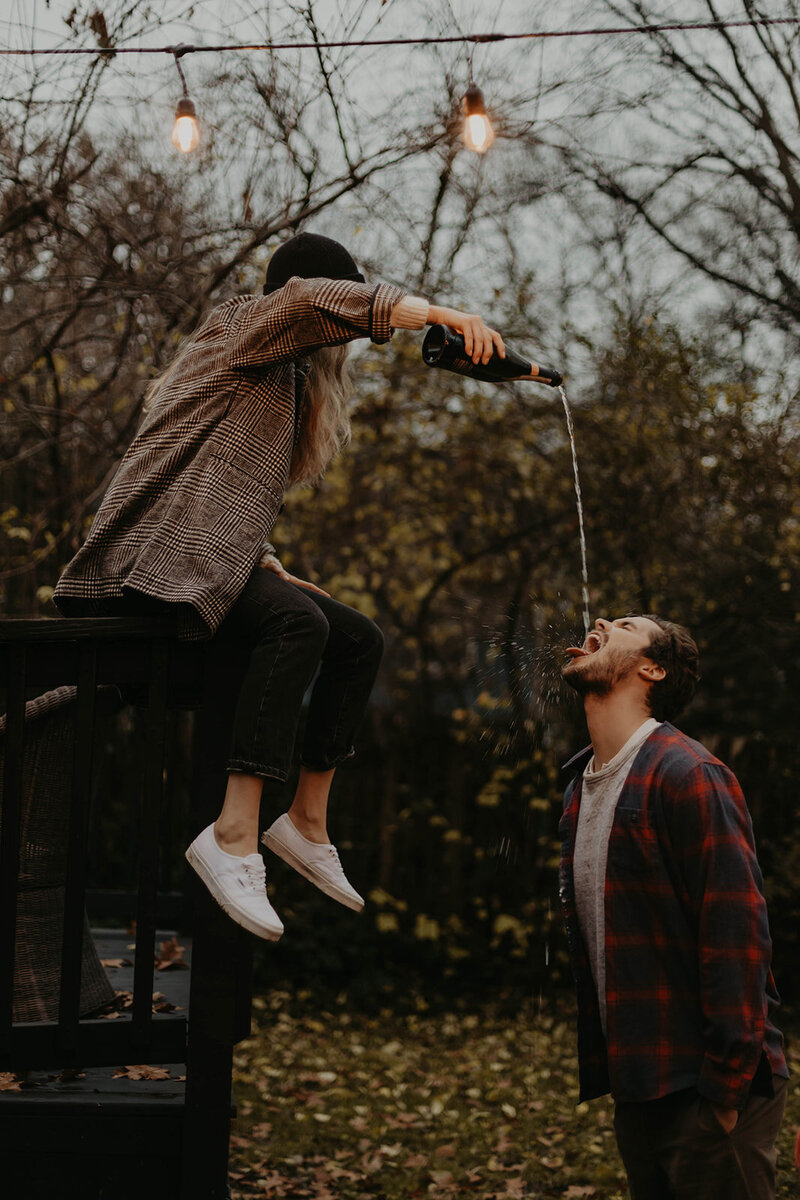 woman pouring champagne into fiances mouth