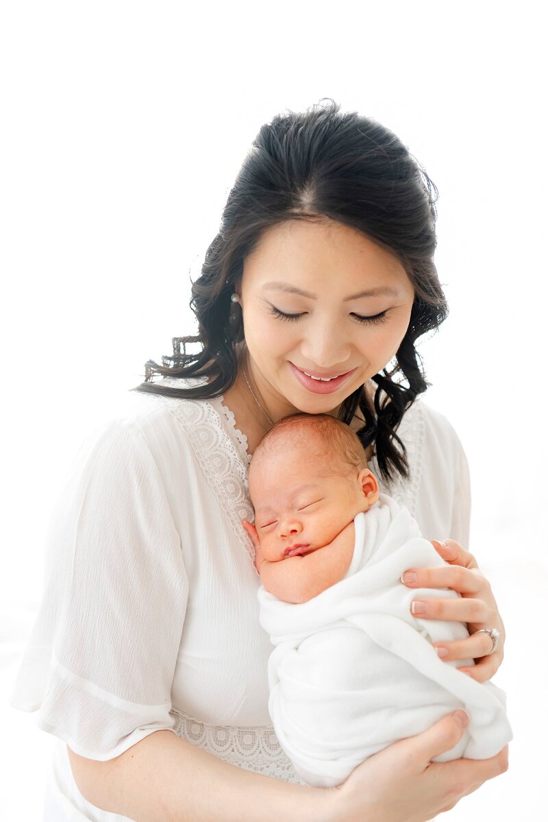 mom holding newborn baby taken by photographer boston​, Beth Miga Photography
