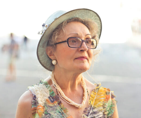 Senior woman with glasses, wearing a sun hat