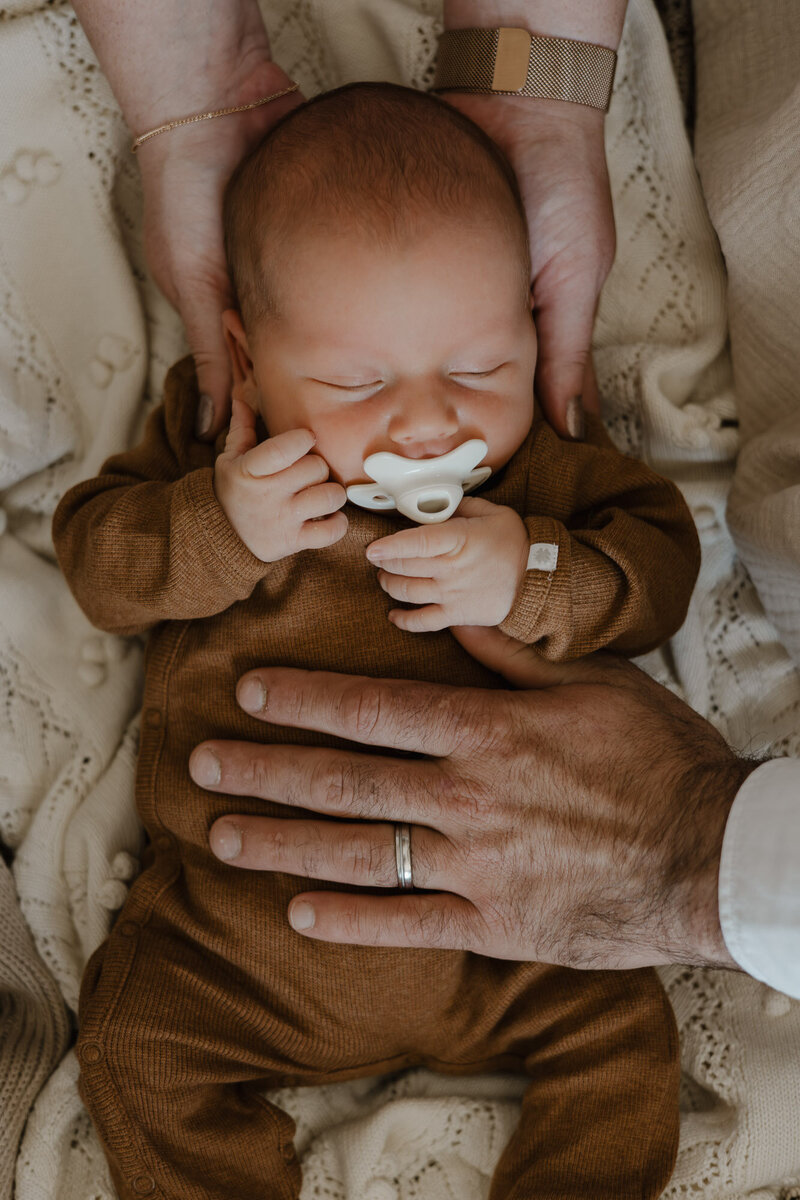 close-up foto van baby met handen van mama en papa erbij