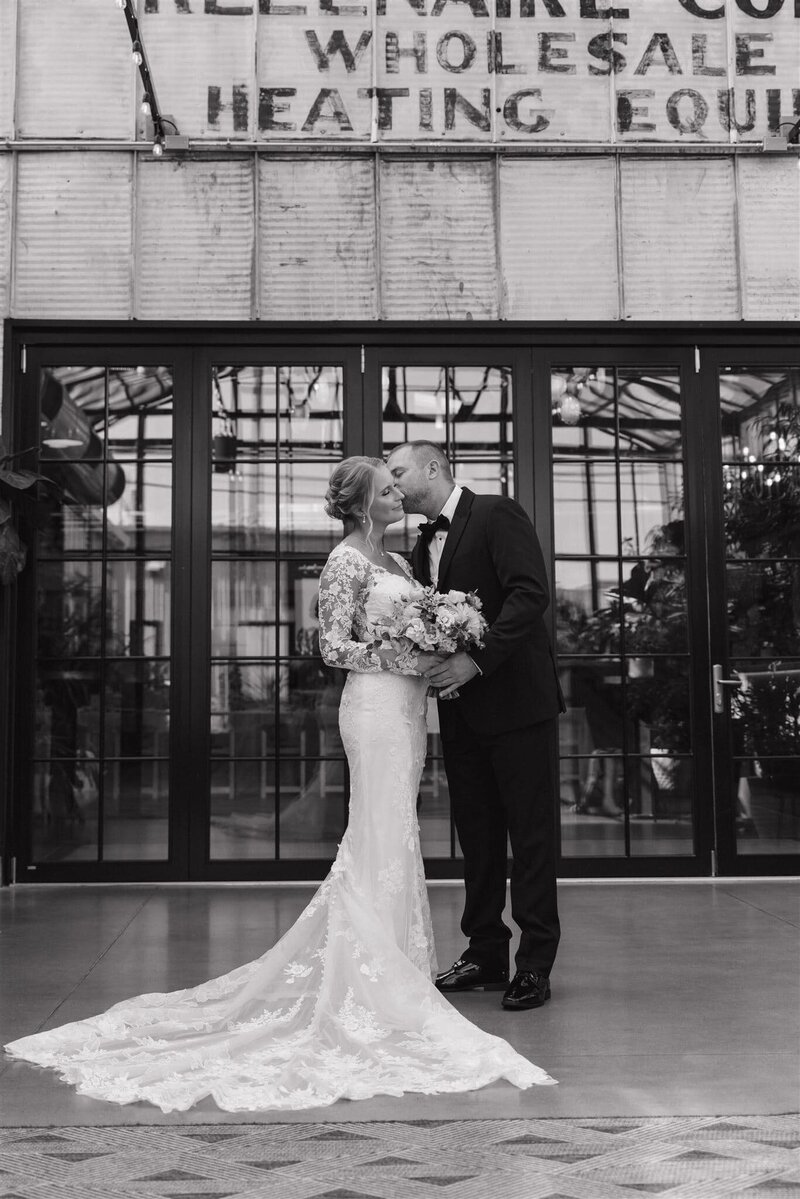 photo of a bride and groom while standing in a solarium or greenhouse taken by Wedding photographer near me