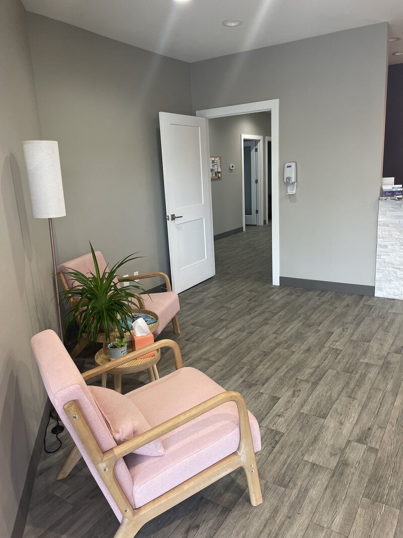 Pink chairs and plant in Rooted Health and Wellness Lobby.