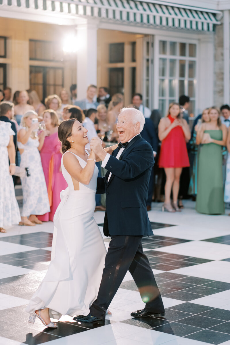 bride and father dance on checkered dance floor at Kansas City Country Club outdoor wedding