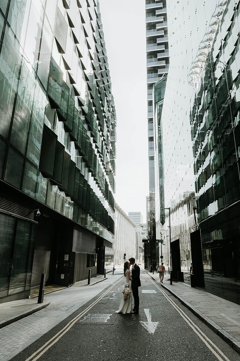 London couple standing between  skyscrapers