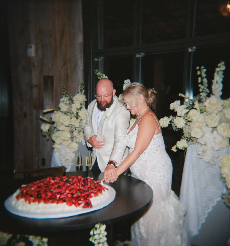 A couple cutting their pavlova wedding cake