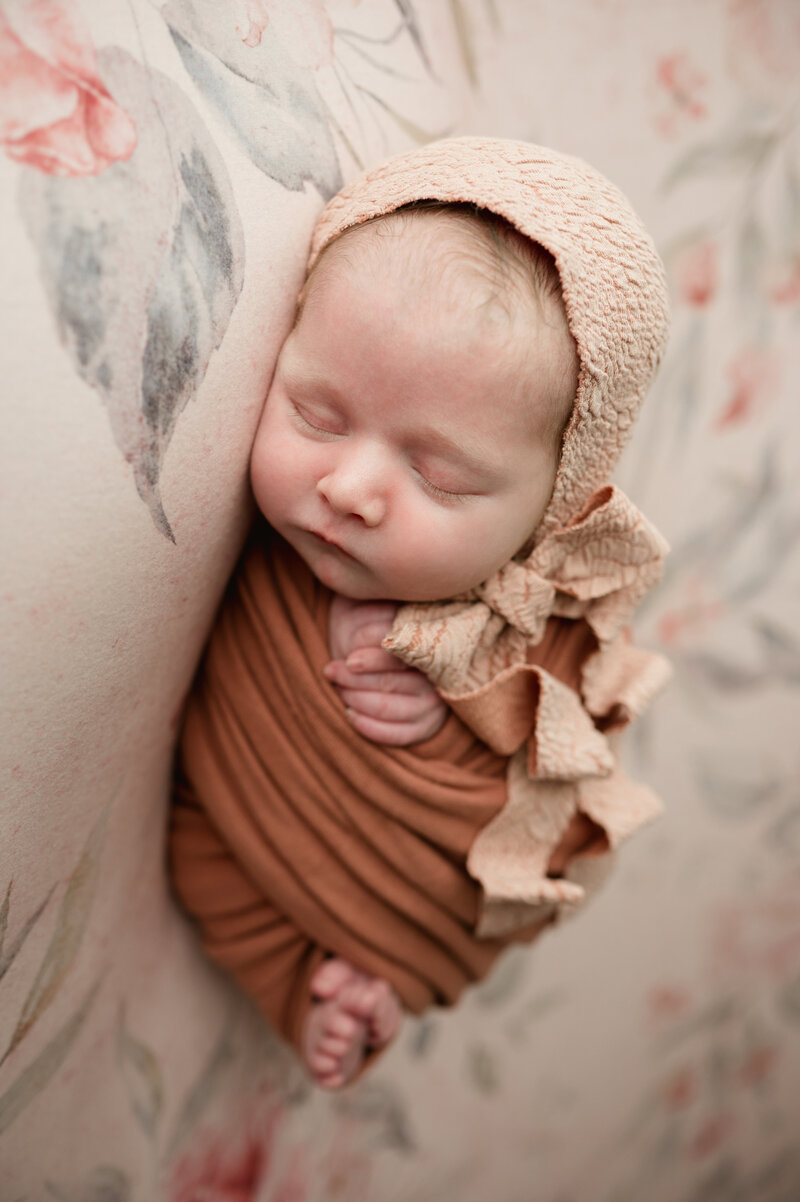 Dad holding newborn wrapped in tan blanket