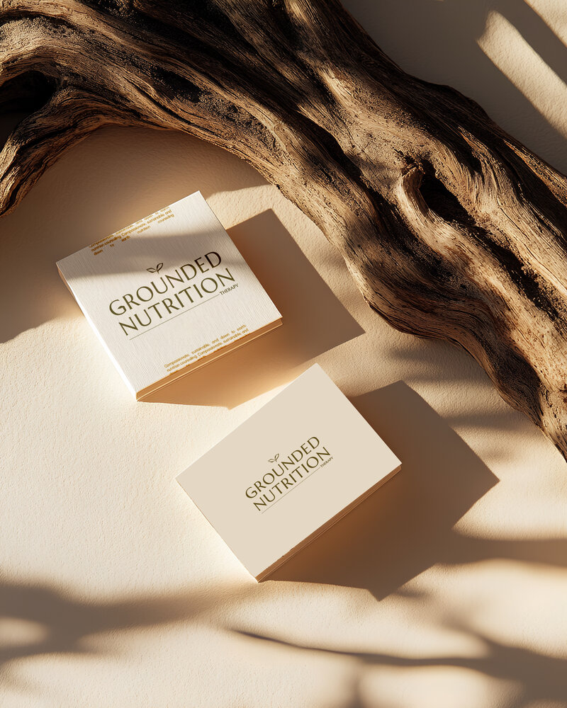 Two boxes showcase branding for a nutritionist next to a piece of driftwood.