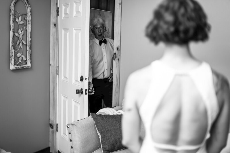 Father of the bride is happily surprised to see his daughter , the bride, in her wedding dress