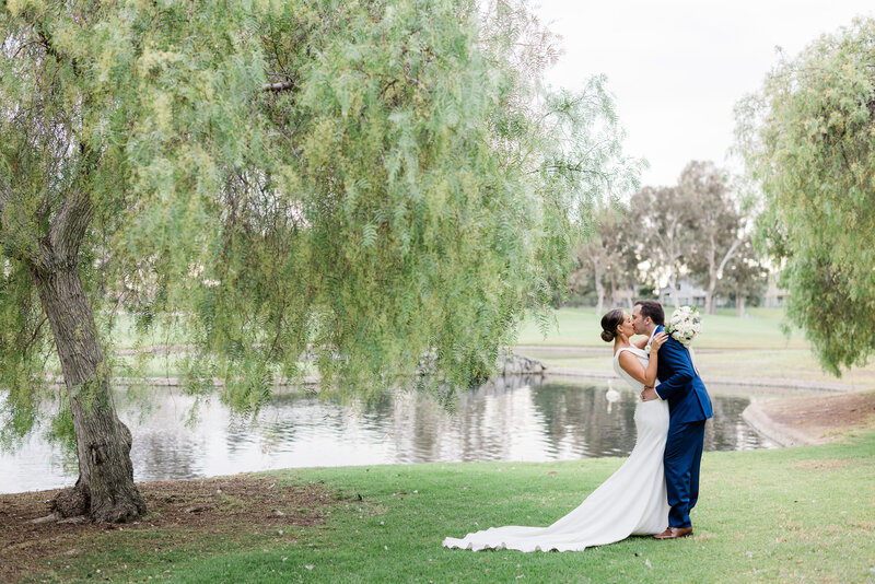bride and groom kissing after walking down the aisle at alta vista country club