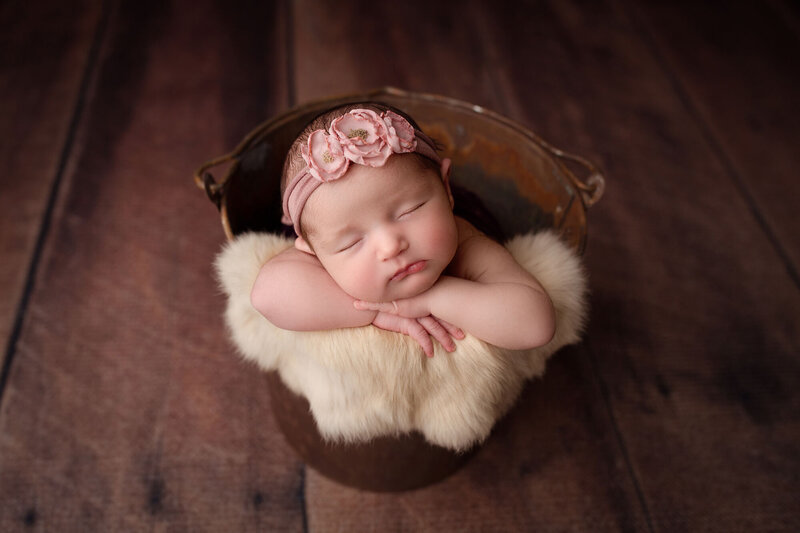baby girl posed in a bucket by a profession NJ photographer