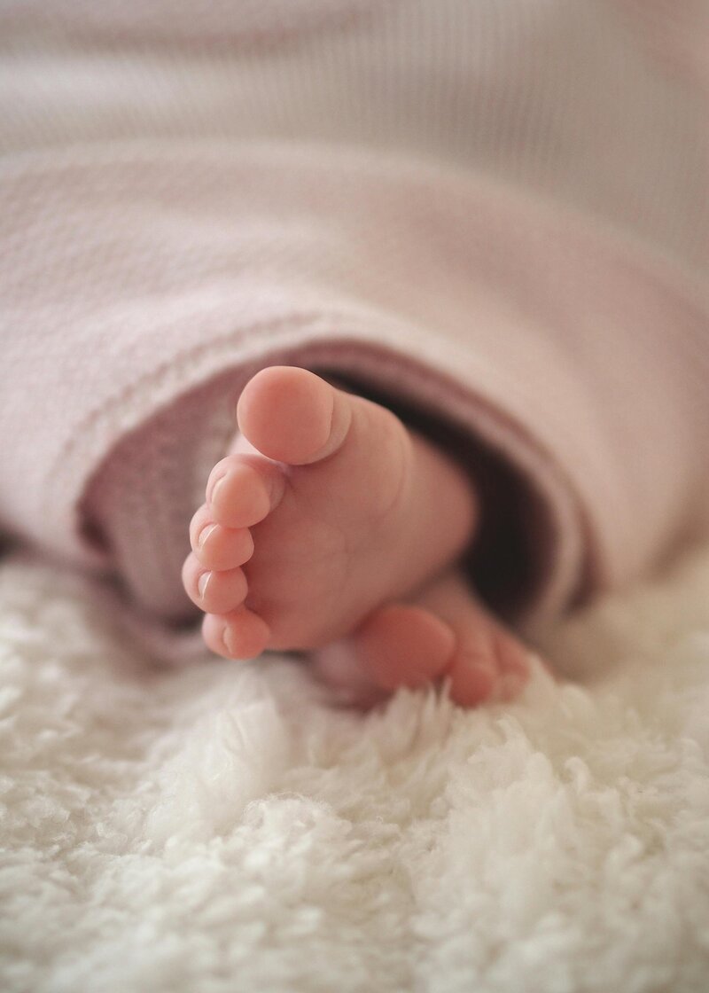 baby feet in a warm crib after navigating a traumatic birth