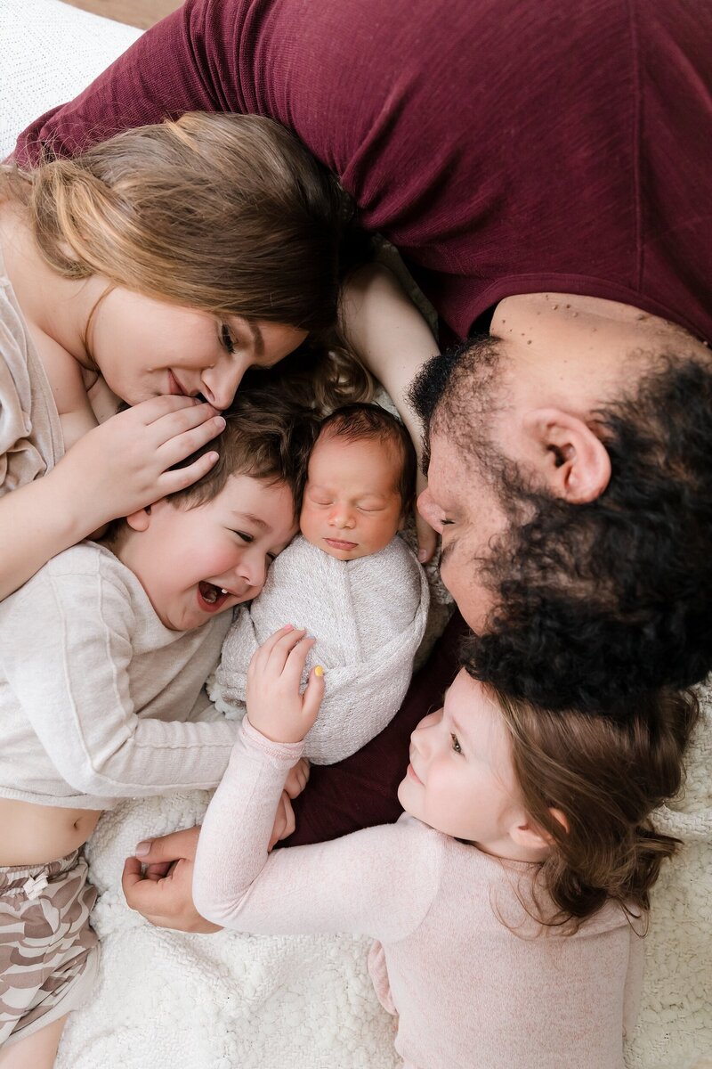 Close up overhead view of large family with newborn baby - happy sibling newborn session Boise Idaho photography studio