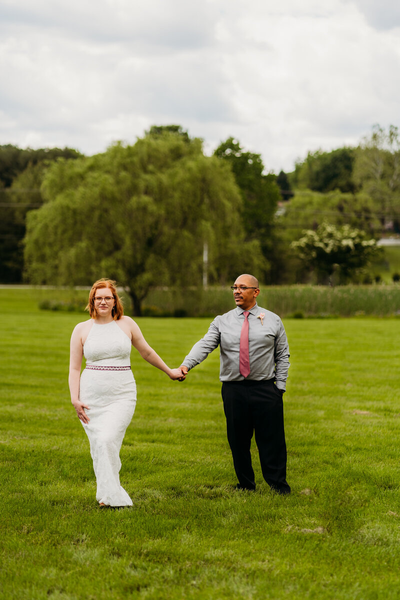Bride and groom share a first dance under a weeping willow during their spring elopement