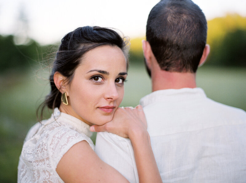 Woman embraces man while looking over her shoulder