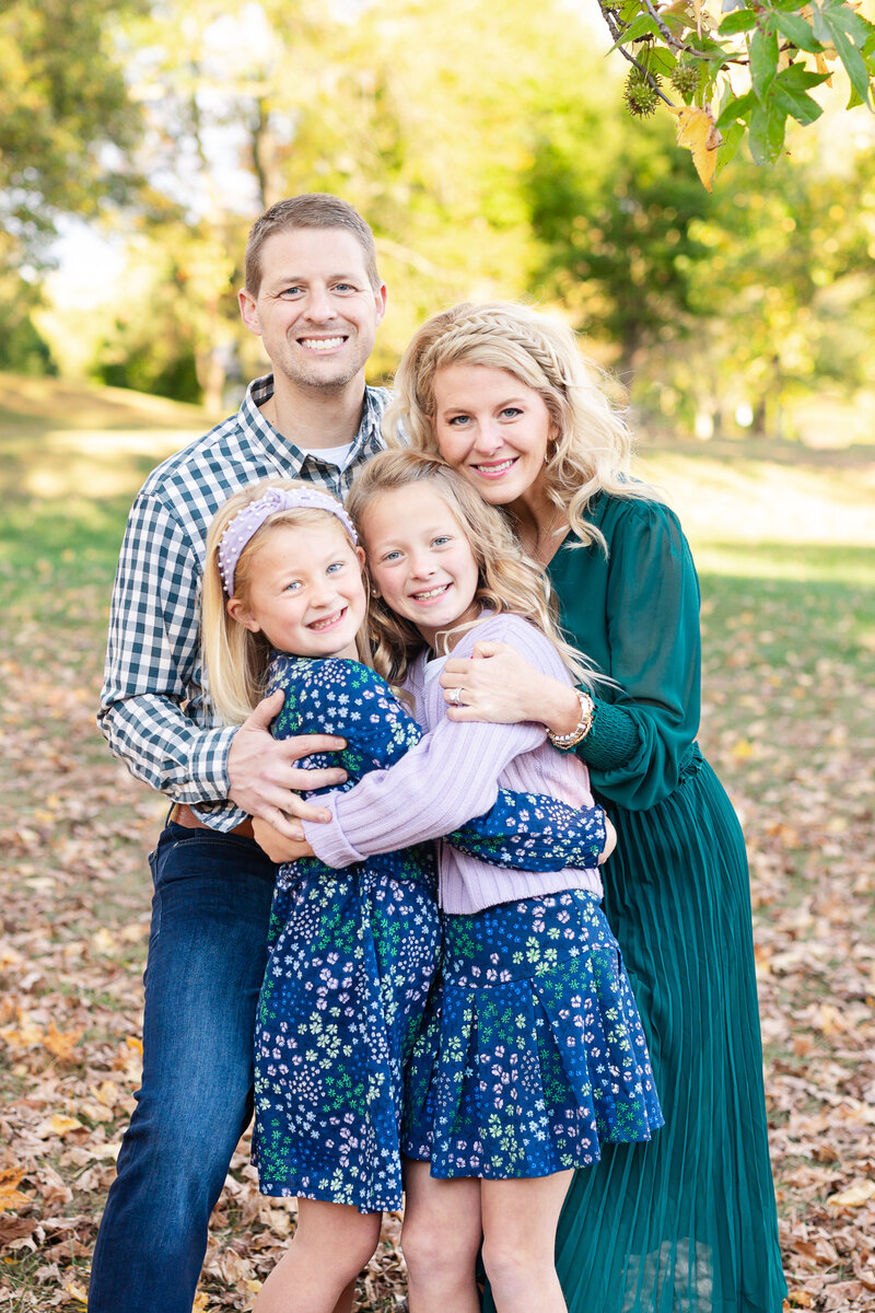 a family of four hugging  for a family photo session