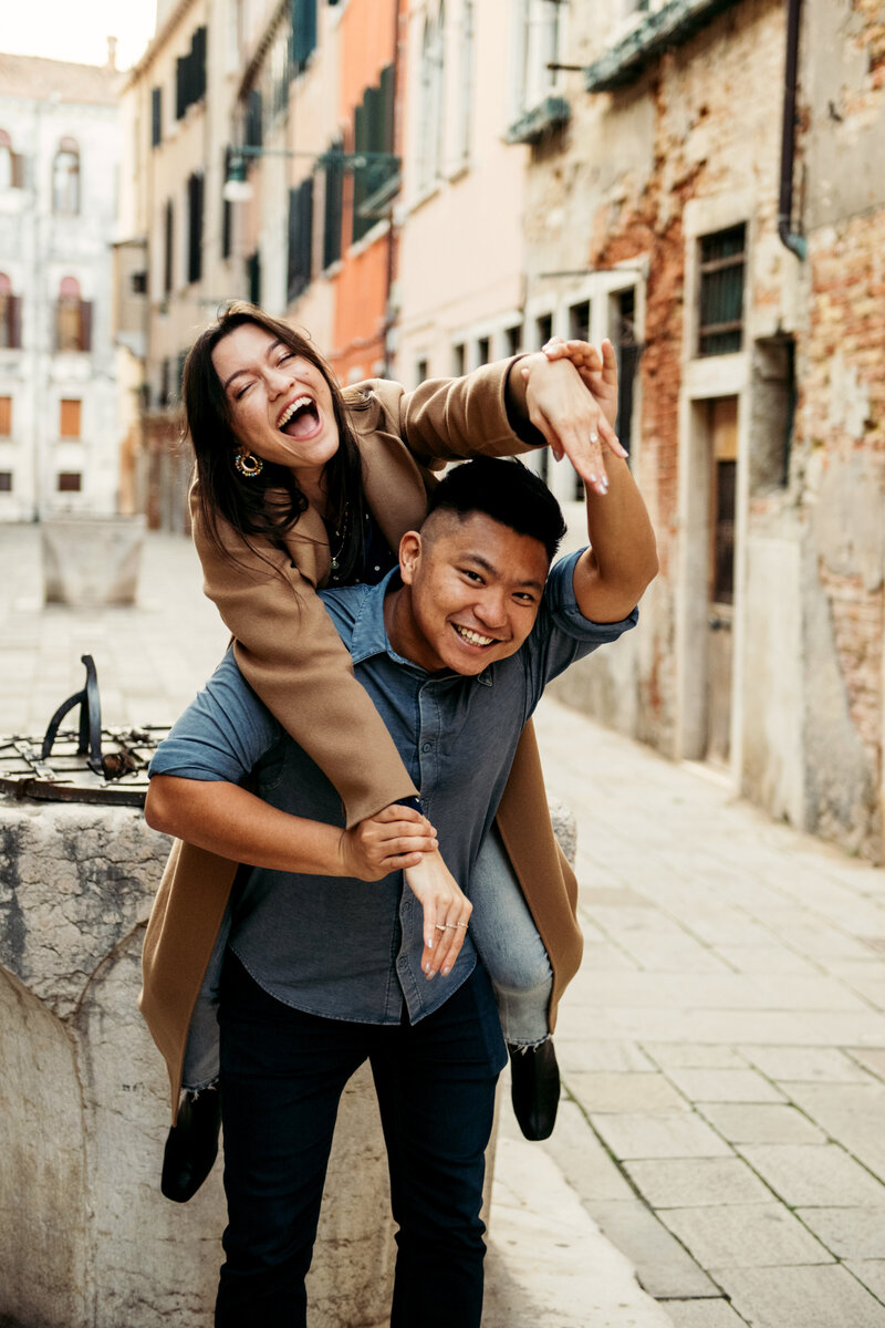 Just engaged couple in a piggyback, the girl is so happy and showing off the engagement ring