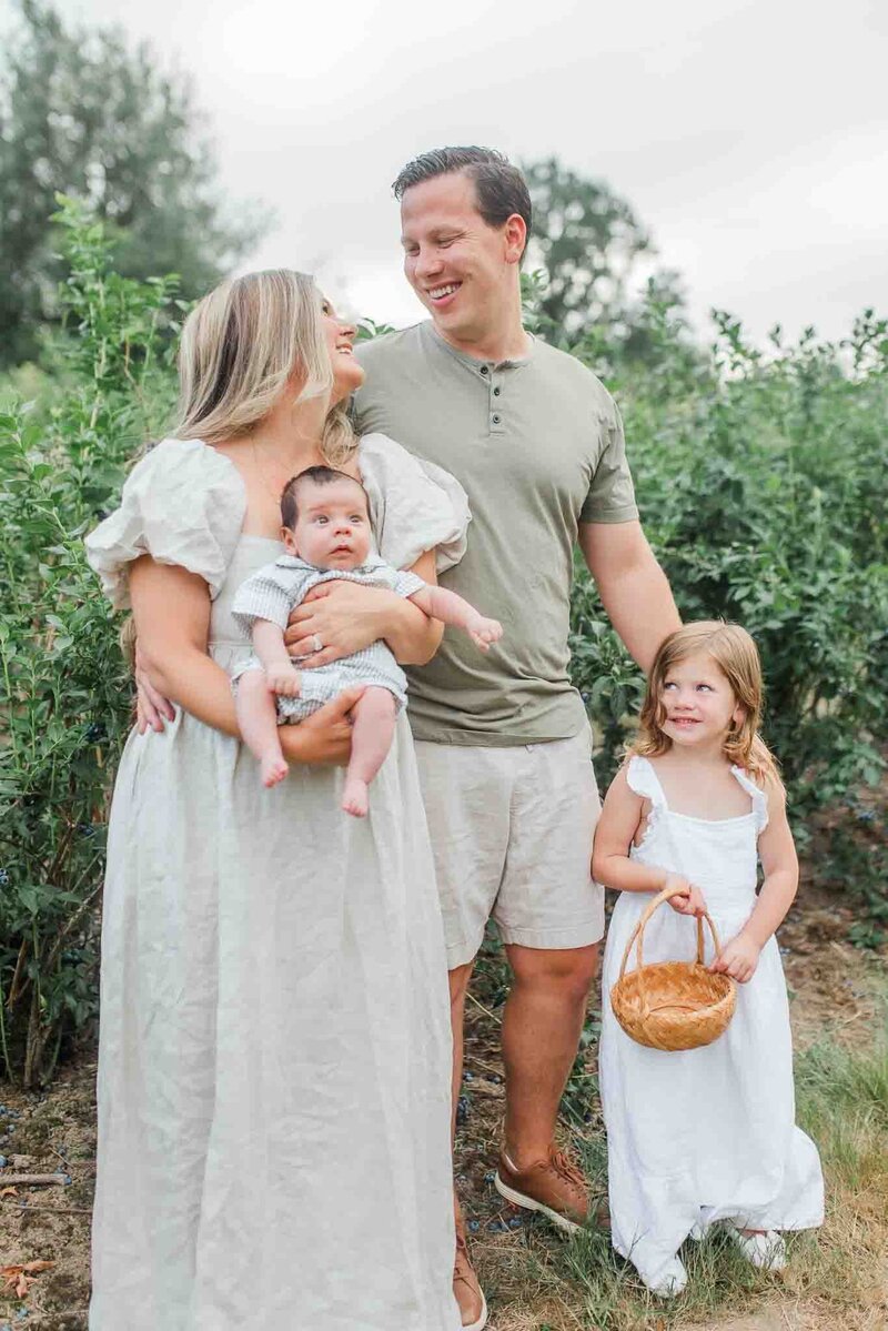 A family photo session with two parents smiling at each other. Photograph taken by Cams, Washington Family Photographer.