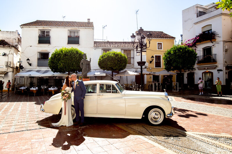 bride and groom sitting on bench with their dog