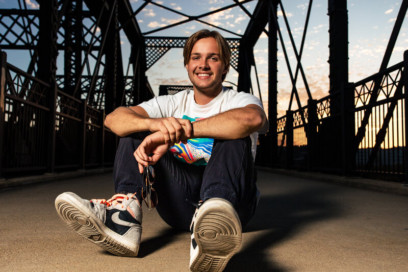 Senior photo of boy on iconic Pittsburgh bridge at true sunset