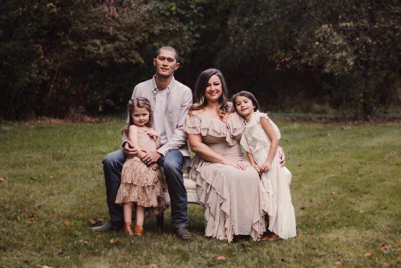 Family Portrait of a beautiful family seated together on a settee in a park
