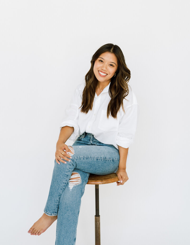 Girl sitting on stool and smiling for photoshoot