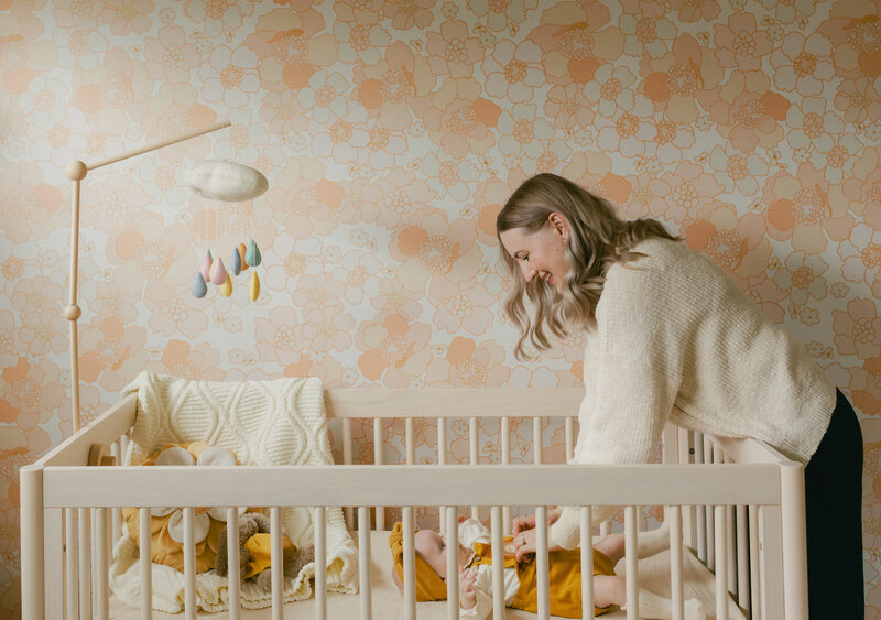 Mother and baby daughter playing in nursery