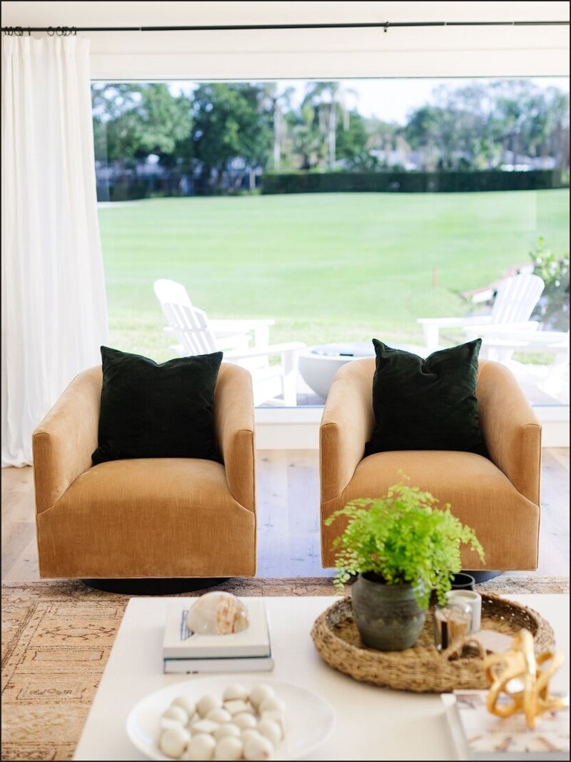 Tan leather accent chairs with black decorative pillows