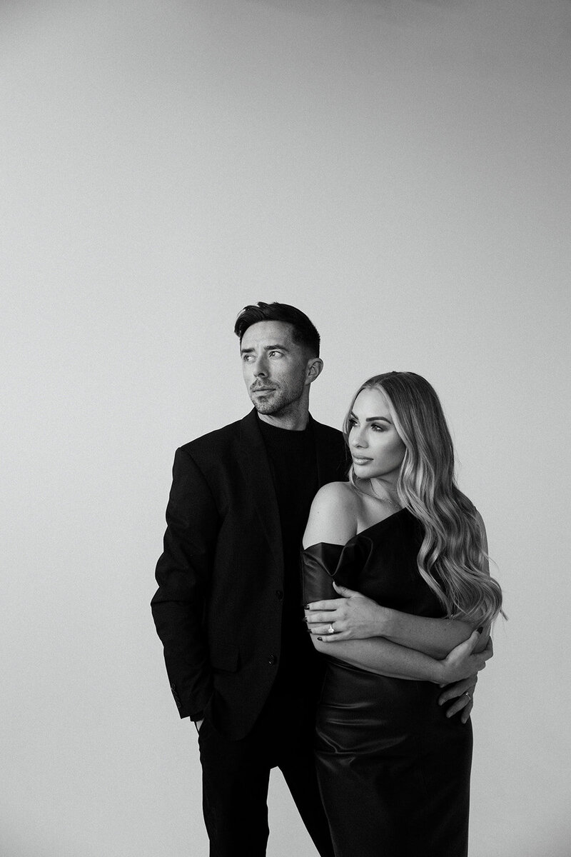 Frazier & Co Photography artists: a stylish and discerning couple in black attire, posed in an editorial fashion for a luxury high-end wedding photographer brand.