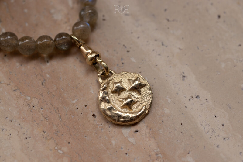 geelgouden hanger met maan en sterren aan kralenketting