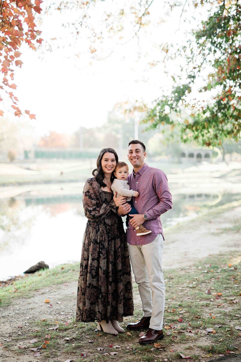 Mom, dad, and young son standing together while smiling