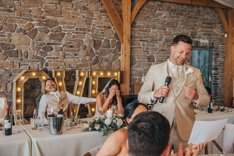 Bride and groom laugh during speeches