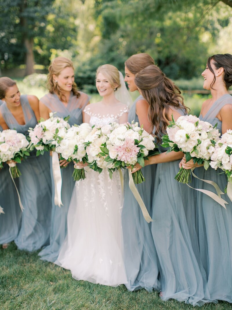 Bride and bridesmaids in blue with whtie and pink bouquets