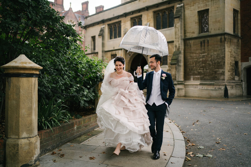 A bride and groom walking in the rain on their wedding day