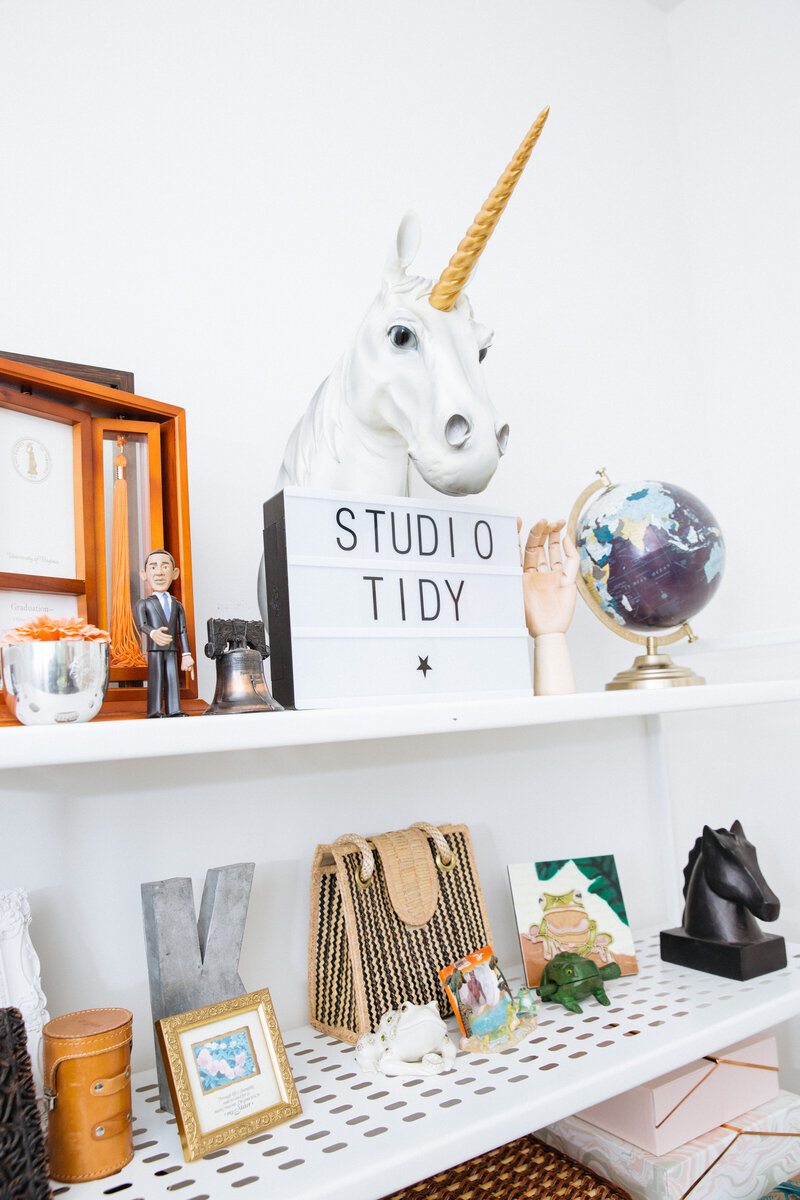 White office shelves with books and a unicorn
