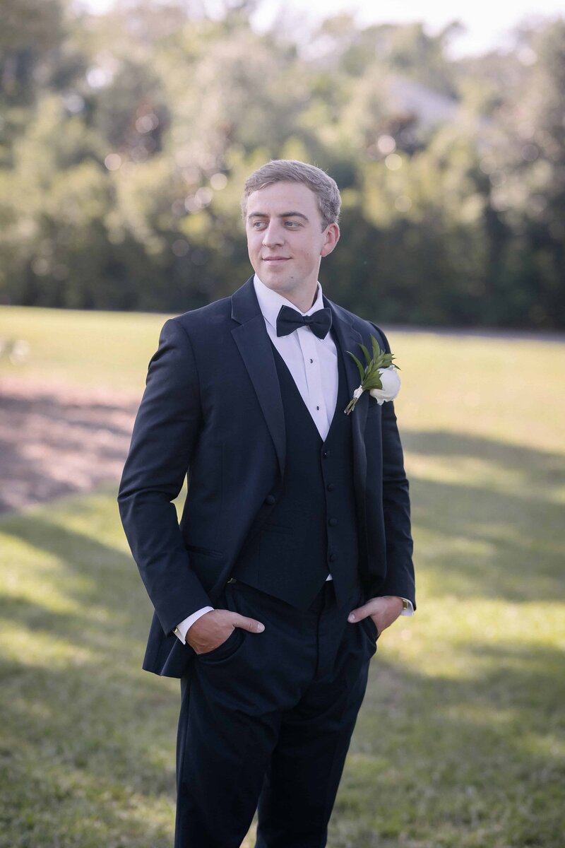 A groom’s portrait taken at The Sandpiper in Waverly, GA by Phavy Photography, a luxury St. Simon’s wedding photographer. With hands in pockets and a soft smile, this editorial-style image captures quiet confidence and timeless elegance—perfect for couples planning a wedding in St. Simon’s or Jekyll Island.