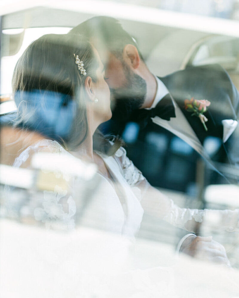 A timeless photograph of a bride and groom sitting together in a luxury vehicle during their portrait session at the Fairmont Jasper Park Lodge in Jasper National Park.