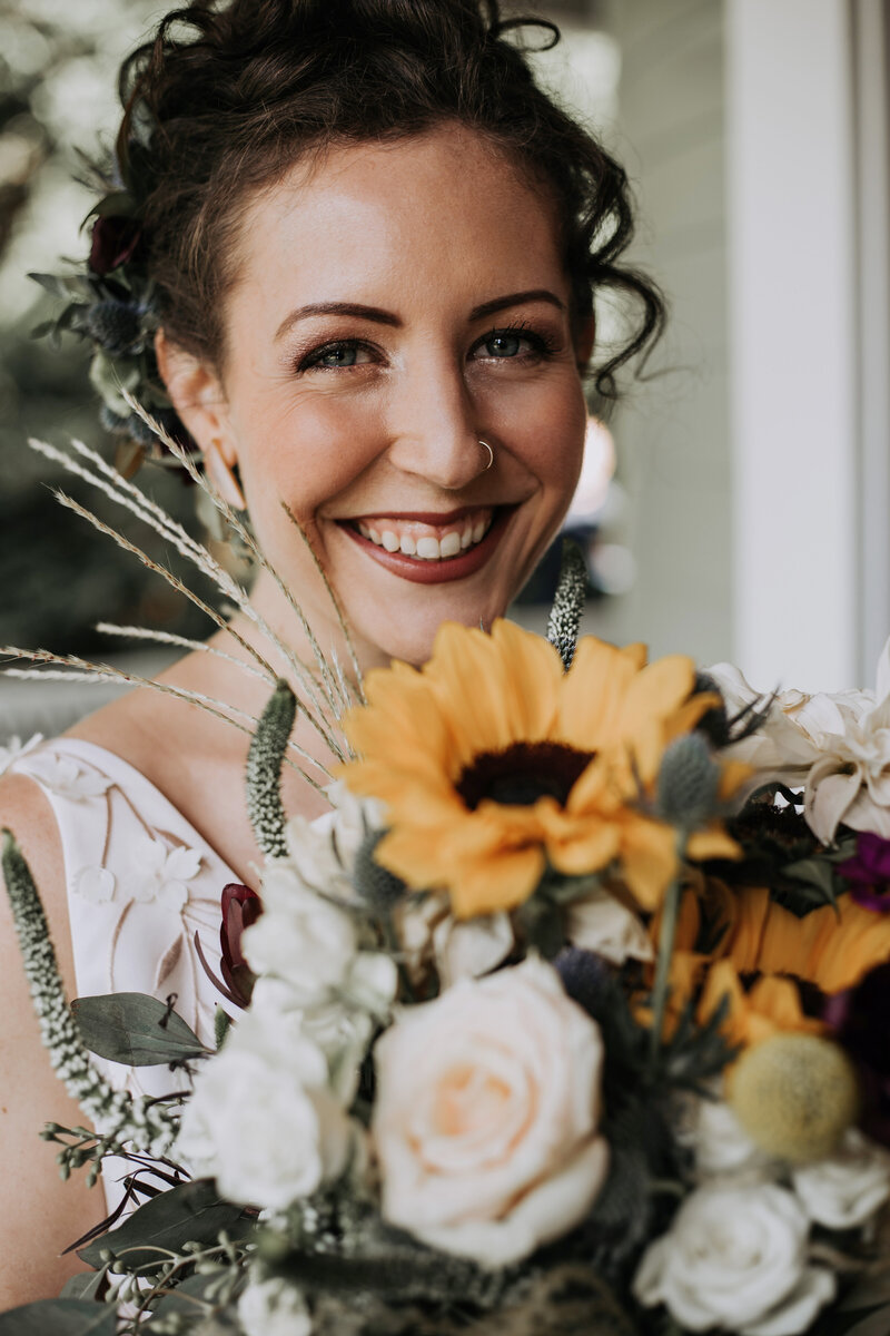 bride smiling holding sunflowers